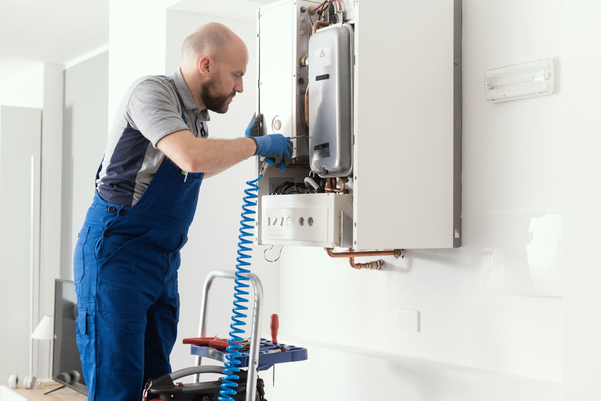 Professional engineer servicing a boiler at home